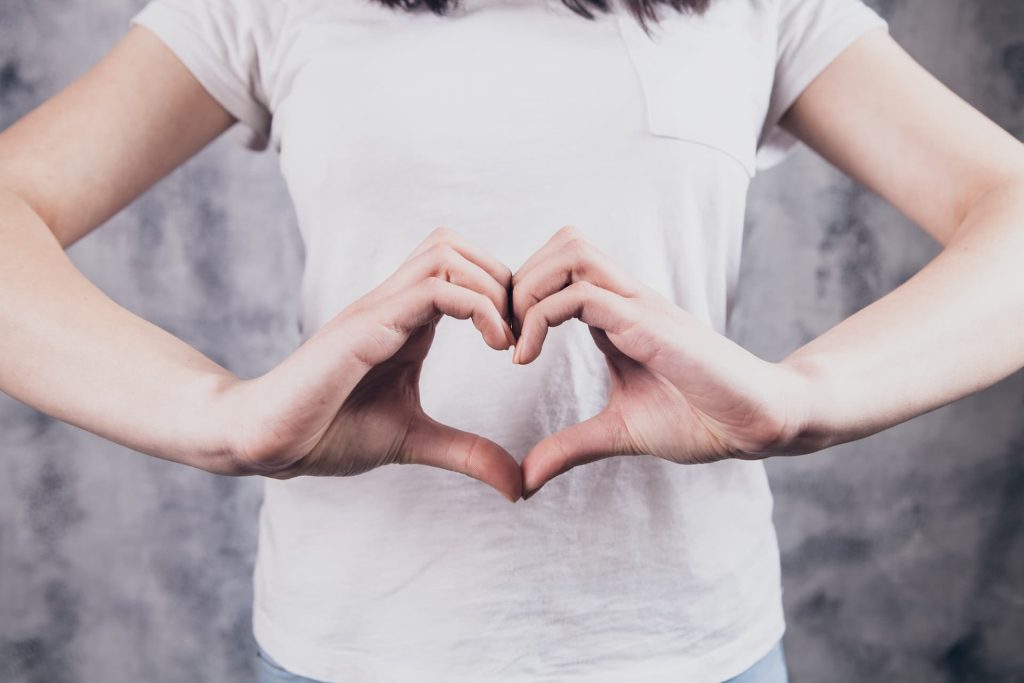 beautiful girl in makes a heart gesture with her hands